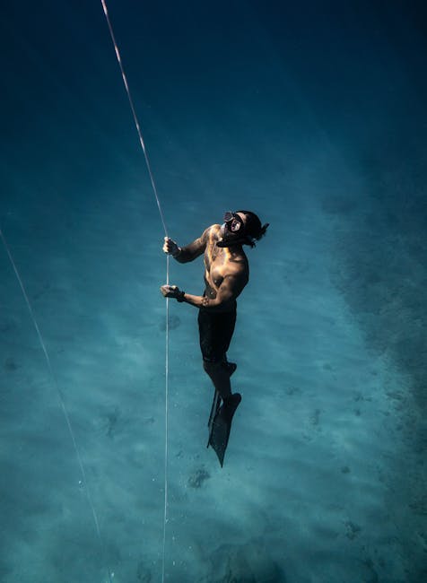 Freediver gracefully ascends in clear ocean waters of Hawaii, showcasing the beauty of underwater exploration.